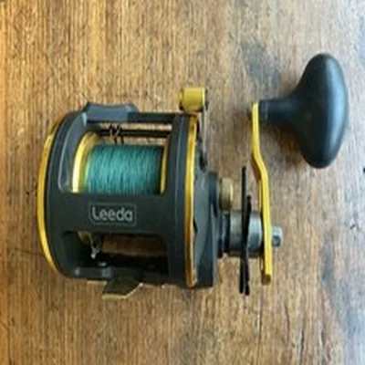 Leeda Icon M30 multiplier fishing reel, spool full of line and a storage pouch